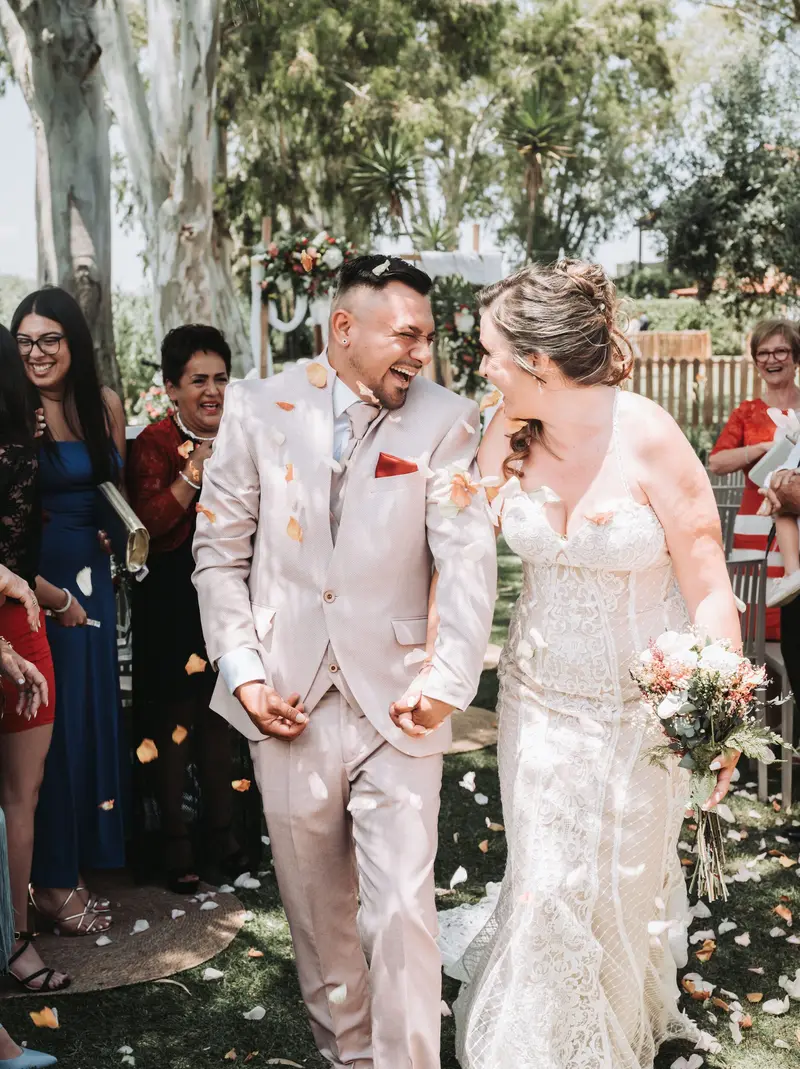 Couple laughing under falling petals — why film wedding photography is trending
